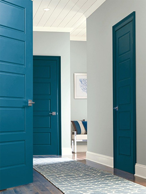 A white hallway with teal painted doors
