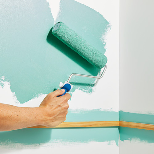 Paint being rolled onto a wall near a section that has been cut in