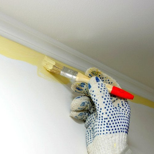 The edge at the top of the wall next to the ceiling being cut in with yellow paint
