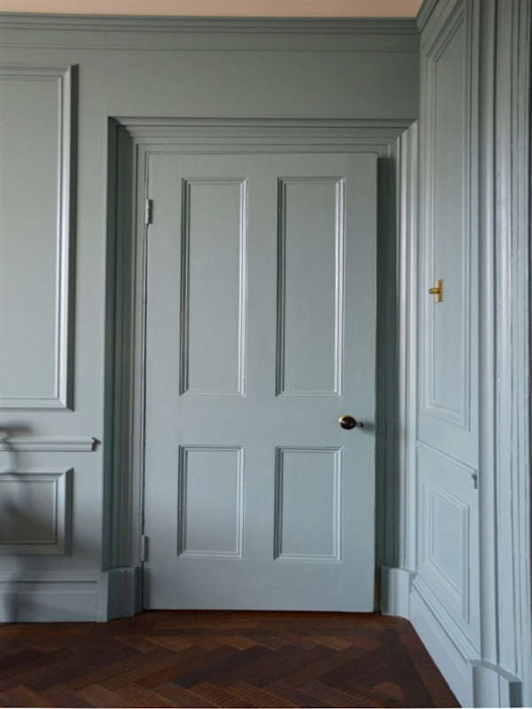 A hallway that has walls and doors painted in the same colour - sage.