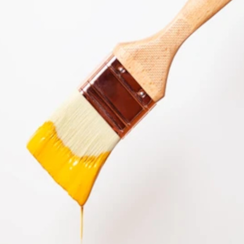 A paintbrush with a tip that is dripping in paint