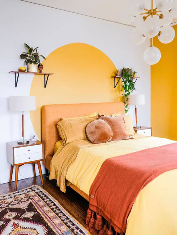 A bedroom with an orange curved bedboard painted above the bed.