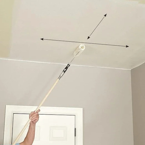 A ceiling being painted with a roller attached to an extension pole. Arrows shown to demonstrate painting at a 90 degree angle after first coat